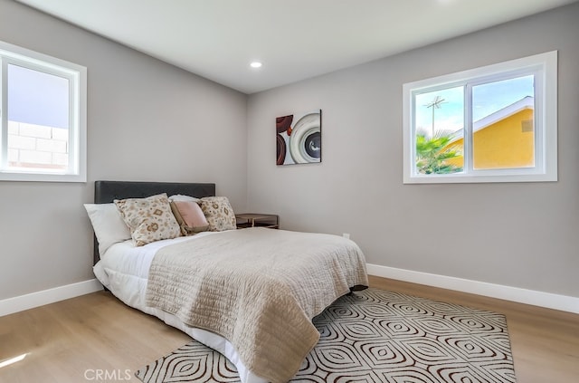 bedroom featuring light wood finished floors, recessed lighting, and baseboards