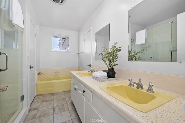 full bathroom featuring double vanity, a shower stall, a sink, and a bath