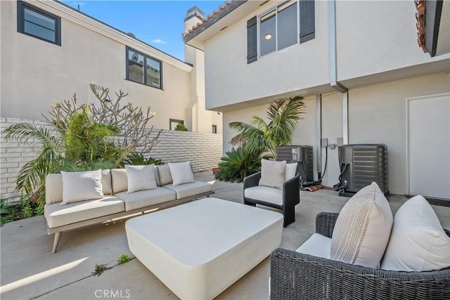 view of patio with an outdoor living space, fence, and cooling unit