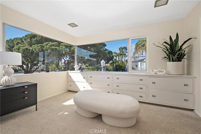 sitting room featuring baseboards, light carpet, and plenty of natural light