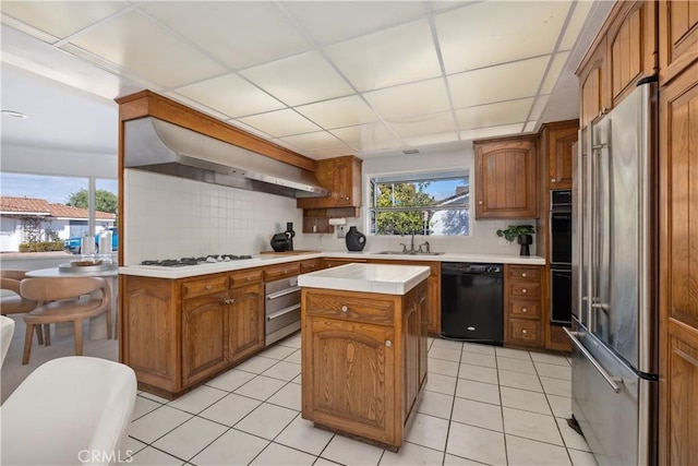 kitchen with a sink, ventilation hood, backsplash, and black appliances