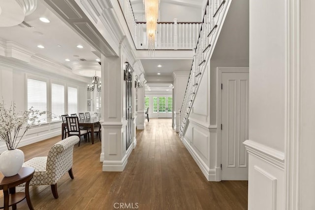 corridor with recessed lighting, crown molding, a decorative wall, and hardwood / wood-style flooring