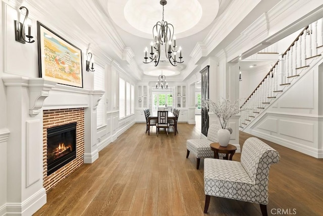 interior space with stairs, a decorative wall, an inviting chandelier, and crown molding