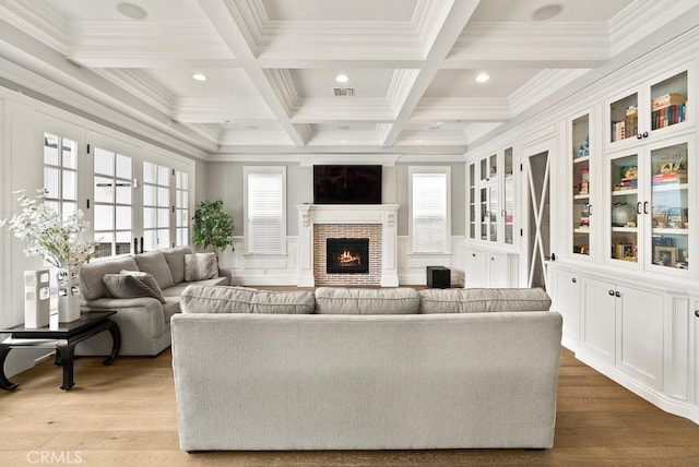 living area featuring ornamental molding, beamed ceiling, and visible vents