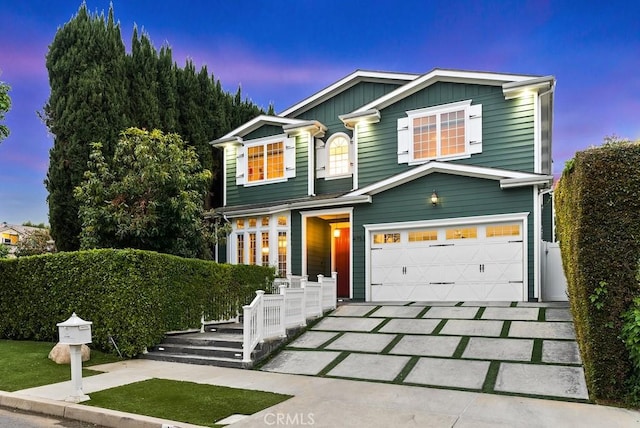 traditional home with concrete driveway, a porch, and an attached garage