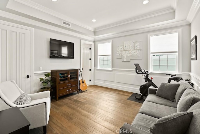 interior space with wood-type flooring, a decorative wall, visible vents, and a wealth of natural light