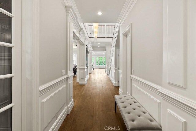 hall featuring recessed lighting, a decorative wall, crown molding, a wainscoted wall, and dark wood-style floors