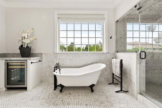bathroom with beverage cooler, tile walls, a stall shower, and ornamental molding