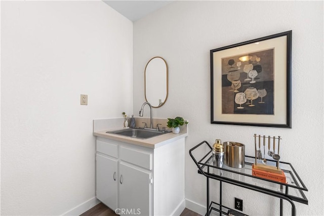 interior space with baseboards, dark wood-style floors, and a sink