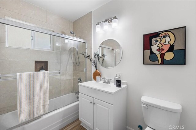 full bathroom with shower / bath combination with glass door, toilet, and vanity