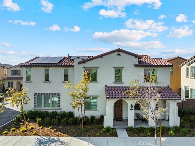 16452 Globetrotter Ave, Chino, CA 91708 - mediterranean / spanish home featuring roof mounted solar panels, a tiled roof, a porch, and stucco siding