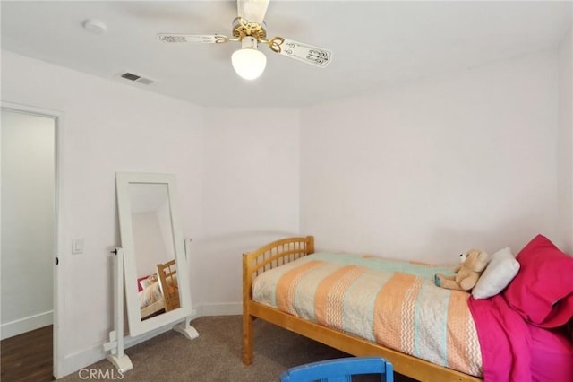 carpeted bedroom with visible vents, a ceiling fan, and baseboards