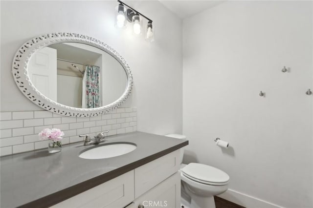 full bath featuring vanity, toilet, a shower with shower curtain, baseboards, and backsplash