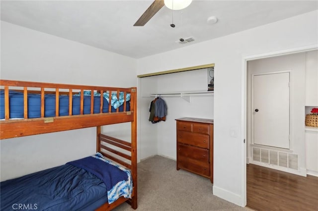 bedroom with ceiling fan, visible vents, carpet, and a closet