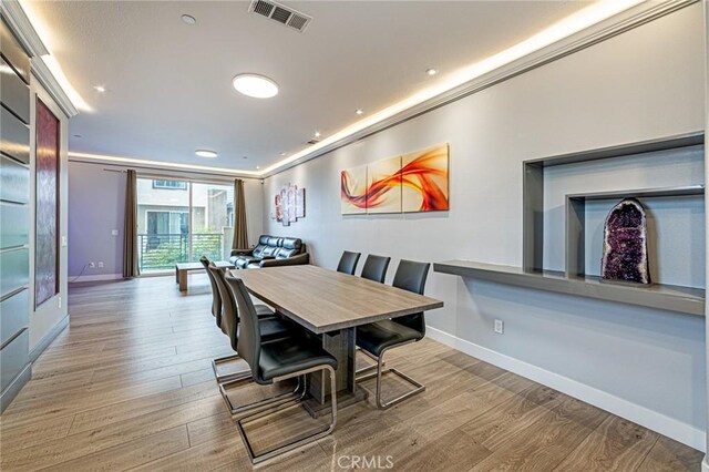 dining room with baseboards, wood finished floors, visible vents, and recessed lighting
