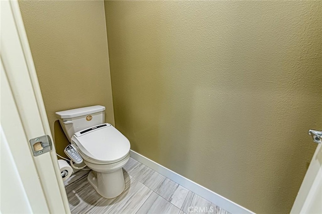 bathroom featuring baseboards and toilet