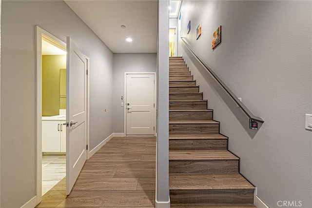 staircase with wood finished floors and baseboards