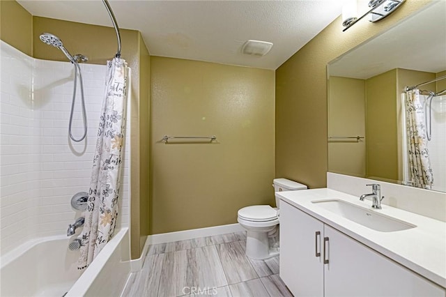 full bathroom featuring toilet, vanity, shower / bath combo with shower curtain, and baseboards