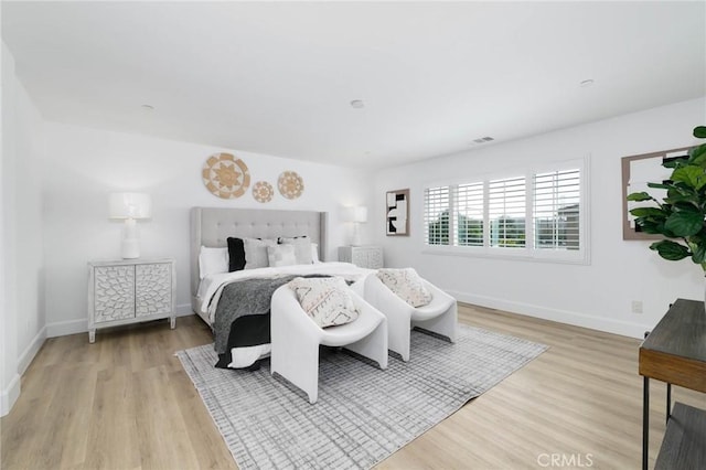 bedroom with light wood-style floors and baseboards