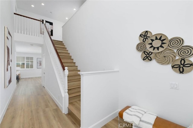 staircase featuring recessed lighting, baseboards, and wood finished floors