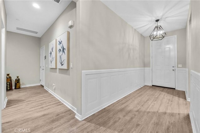 29102 Carrotwood, Lake Elsinore, CA 92530 - hallway with wood finished floors, a chandelier, and a wainscoted wall