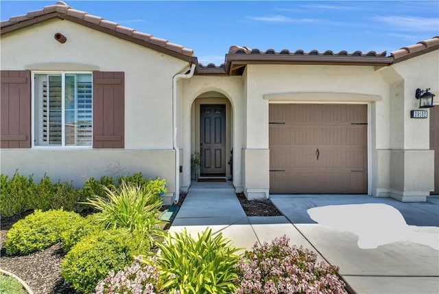 29102 Carrotwood, Lake Elsinore, CA 92530 - doorway to property with a garage, stucco siding, concrete driveway, and a tile roof