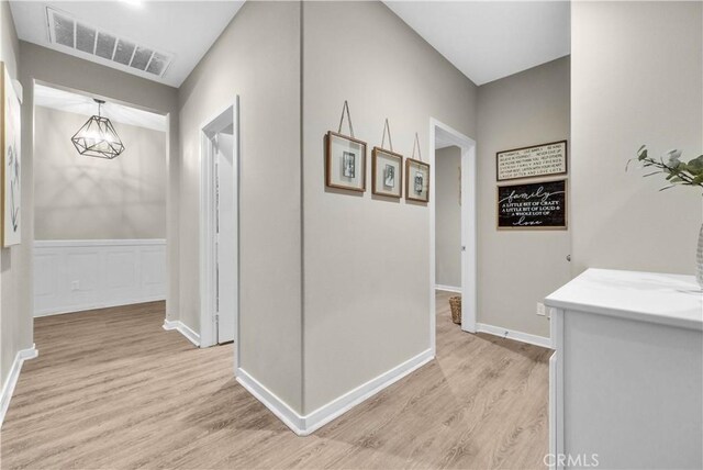 29102 Carrotwood, Lake Elsinore, CA 92530 - hall featuring light wood finished floors, a chandelier, and wainscoting