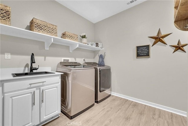 29102 Carrotwood, Lake Elsinore, CA 92530 - washroom featuring washer and dryer, light wood-style floors, and cabinet space