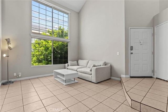 11150 Glenoaks Blvd Unit 98, Pacoima, CA 91331 - living room with light tile patterned floors, a healthy amount of sunlight, high vaulted ceiling, and baseboards