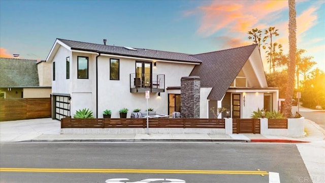 491 Prospect St, Newport Beach, CA 92663 - view of front of property with a balcony, a fenced front yard, an attached garage, stucco siding, and concrete driveway