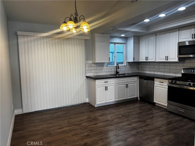 1912 W Quartermaster St, Colton, CA 92324 - kitchen with stainless steel appliances, a chandelier, dark countertops, dark wood-style flooring, and backsplash