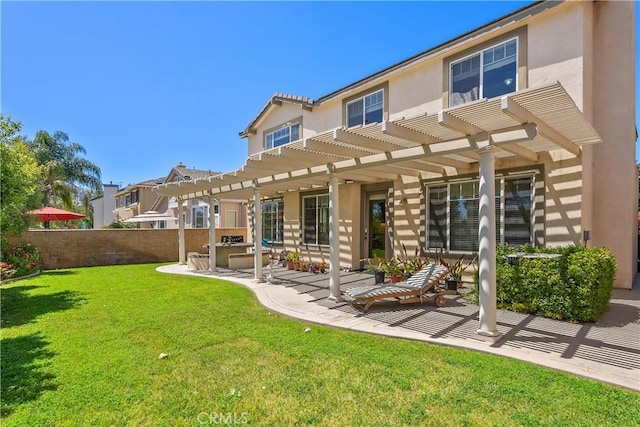 back of property with a patio area, fence, a yard, a pergola, and stucco siding
