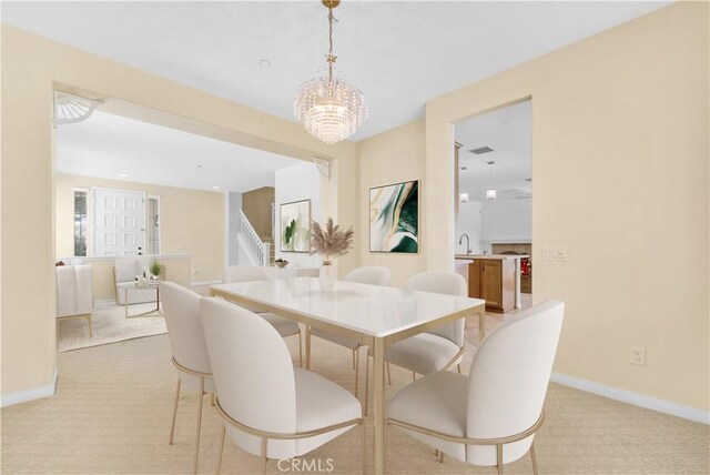 dining room with baseboards, light carpet, and a chandelier