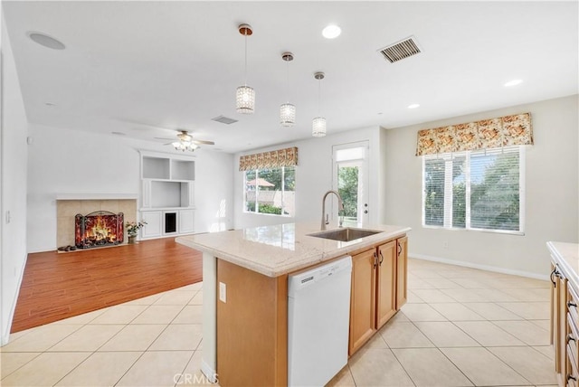 kitchen featuring visible vents, pendant lighting, light tile patterned flooring, a sink, and dishwasher