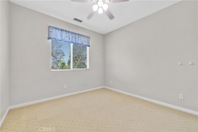 carpeted empty room with a ceiling fan, baseboards, and visible vents