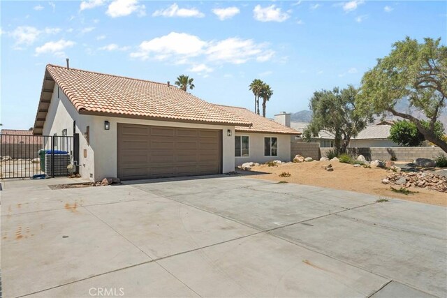 67305 Verona Rd, Cathedral City, CA 92234 - view of front of house with a garage, driveway, stucco siding, and a tiled roof
