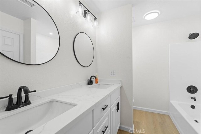 67305 Verona Rd, Cathedral City, CA 92234 - full bathroom with double vanity, wood finished floors, and shower / bath combination