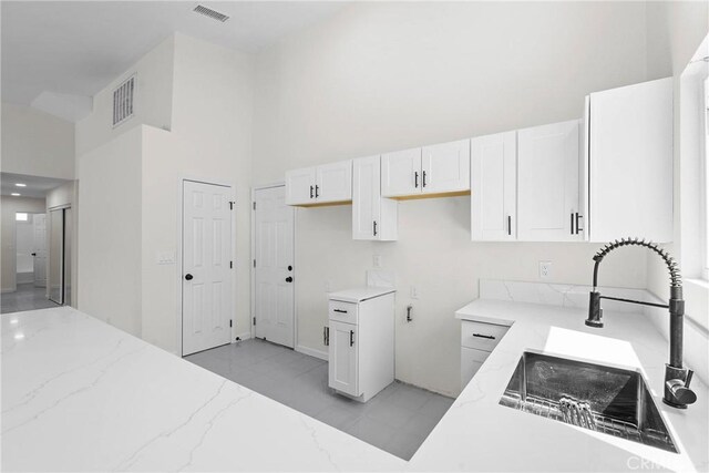 67305 Verona Rd, Cathedral City, CA 92234 - kitchen with a sink, light stone countertops, a high ceiling, and white cabinetry