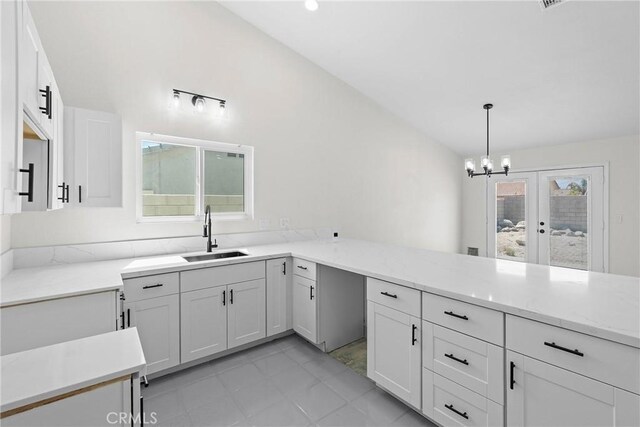 67305 Verona Rd, Cathedral City, CA 92234 - kitchen featuring a sink, vaulted ceiling, light stone counters, white cabinetry, and a chandelier