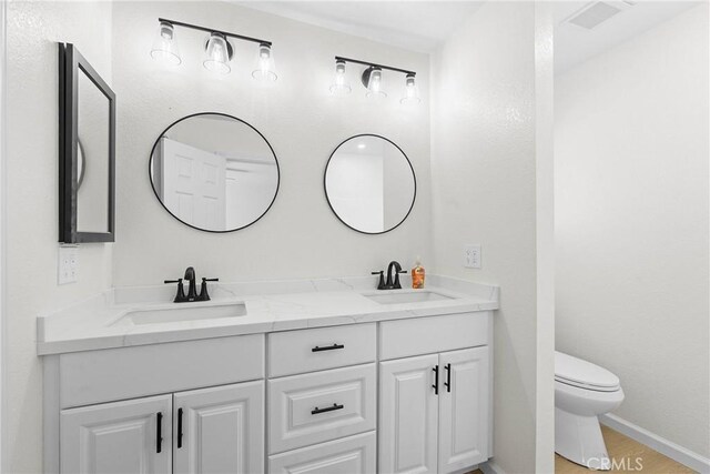 67305 Verona Rd, Cathedral City, CA 92234 - full bathroom with double vanity, toilet, and baseboards