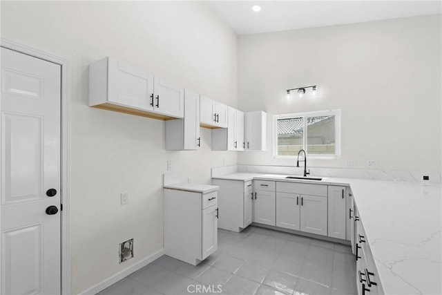 67305 Verona Rd, Cathedral City, CA 92234 - kitchen featuring a sink, light stone counters, a high ceiling, white cabinets, and light tile patterned floors