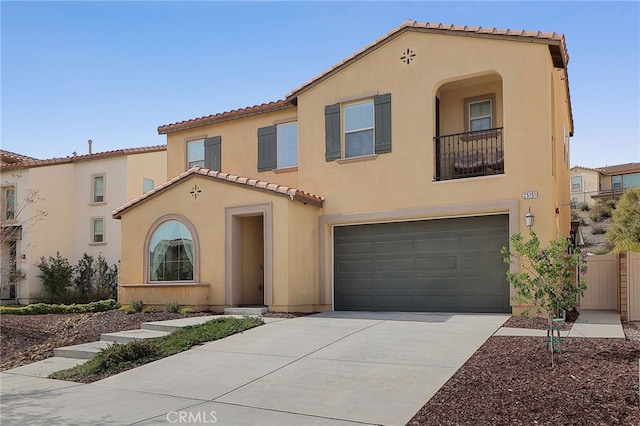 mediterranean / spanish home with stucco siding, a garage, a tile roof, a balcony, and concrete driveway