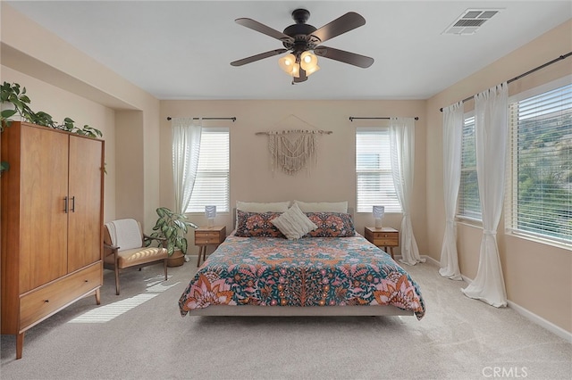 bedroom with visible vents, ceiling fan, baseboards, and light carpet