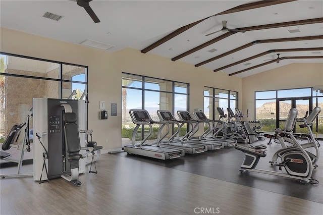 gym featuring wood finished floors, visible vents, a ceiling fan, and high vaulted ceiling
