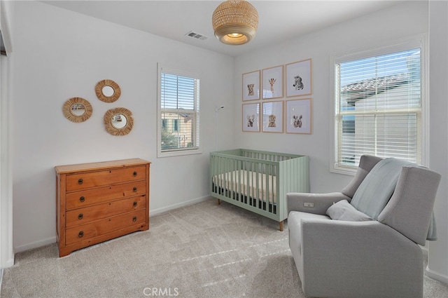 bedroom with carpet, visible vents, a nursery area, and multiple windows