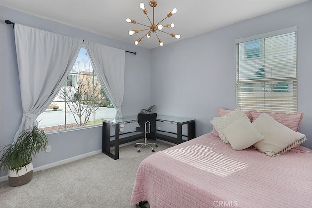 carpeted bedroom featuring baseboards and a notable chandelier