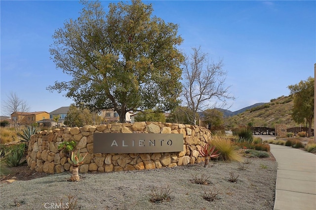 community / neighborhood sign with a mountain view