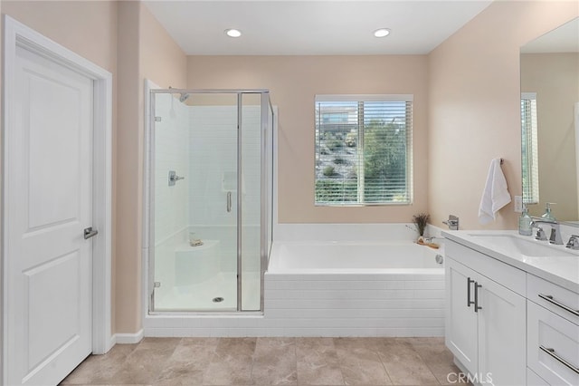 bathroom with a shower stall, a bath, and vanity