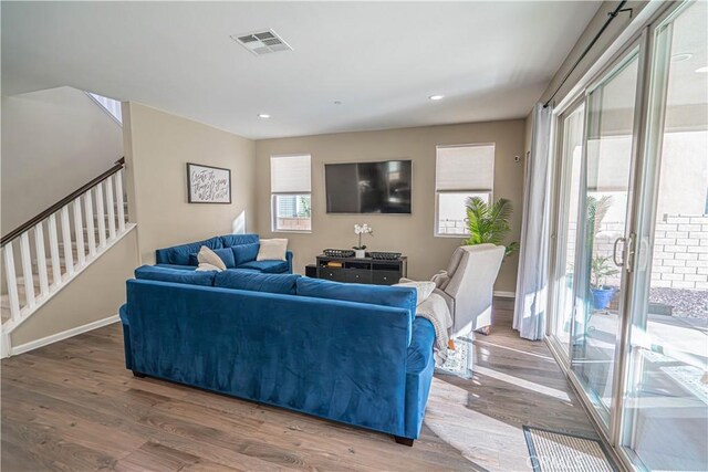 living area with recessed lighting, wood finished floors, stairway, baseboards, and visible vents