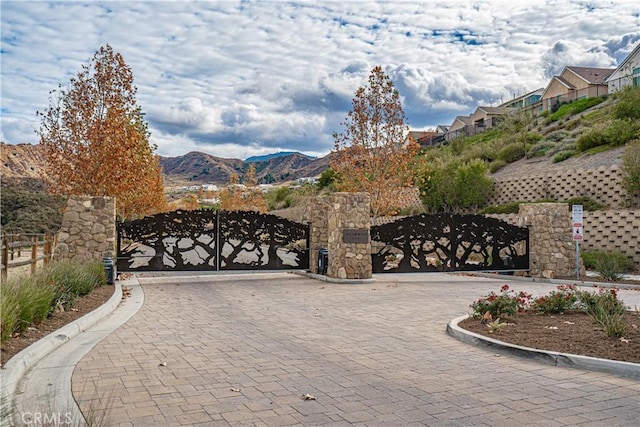 view of gate with a mountain view and fence